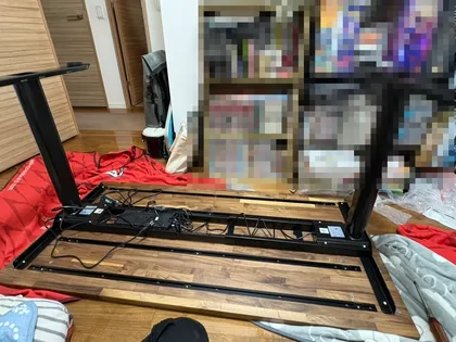 ブランケットを敷いた床の上で脚を取り付けている途中のデスク